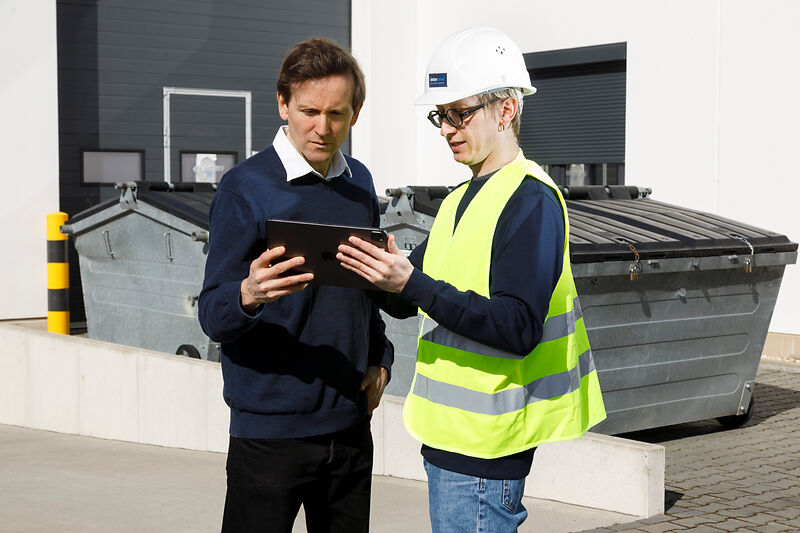 Two men arrange for waste collection via the Interzero platform.
