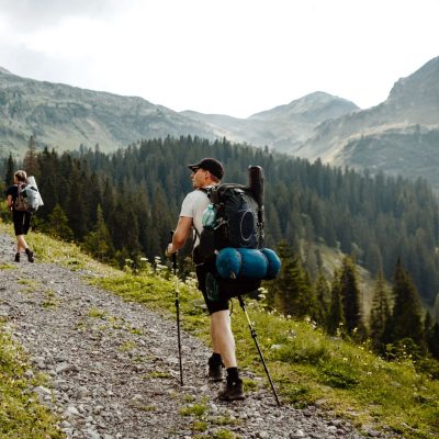 Ein junger Mann mit einem großen Rucksack wandert durch hohe Berge